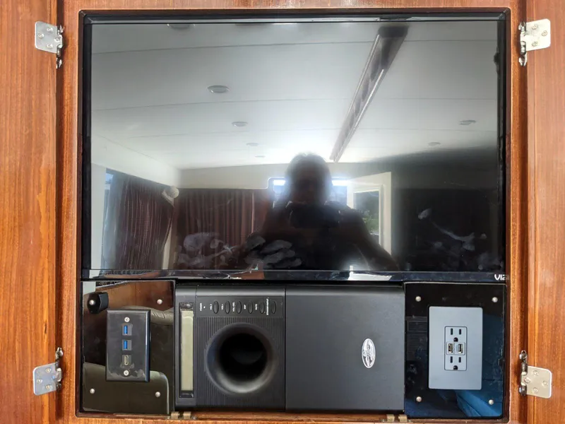 Slide: The Image of 1977 Hatteras 46 Convertible interior with mounted TV and electronic components. - 14