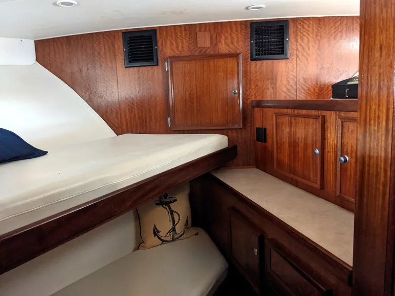 Slide: The Image of 1977 Hatteras 46 Convertible cabin interior with wooden cabinetry and bedding. - 16