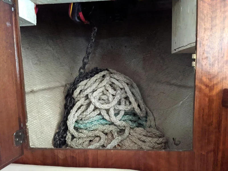 Slide: The Image of Coiled rope and chain in a storage compartment of a 1977 Hatteras 46 Convertible boat. - 17