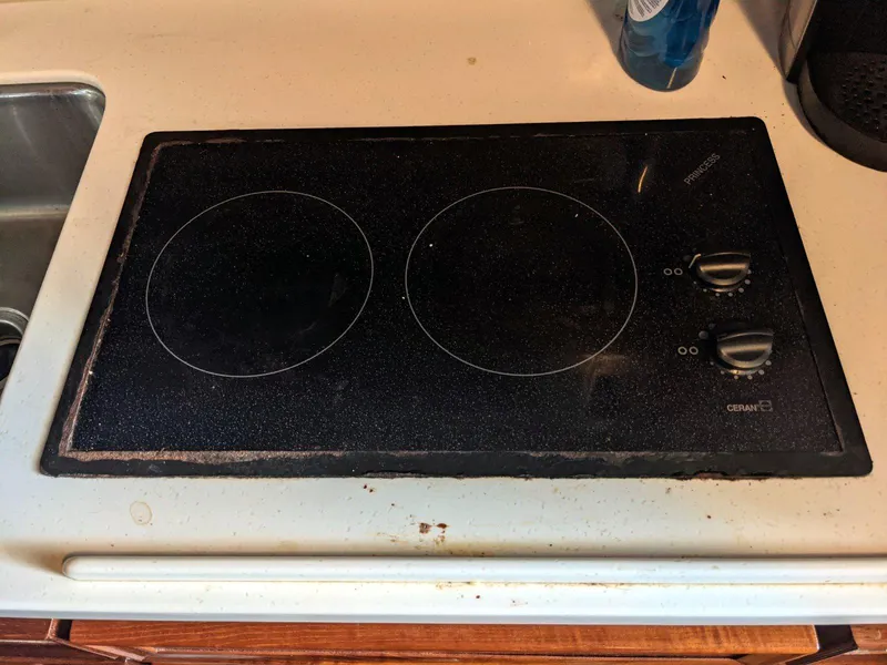 Slide: The Image of Electric stovetop with two burners on a kitchen counter, next to a sink. - 22
