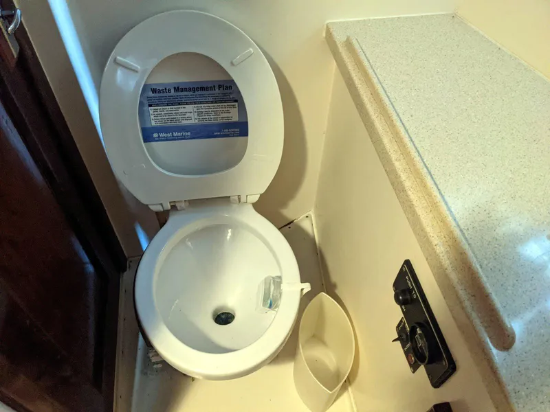 Slide: The Image of 1977 Hatteras 46 Convertible boat bathroom with toilet and waste management plan. - 27