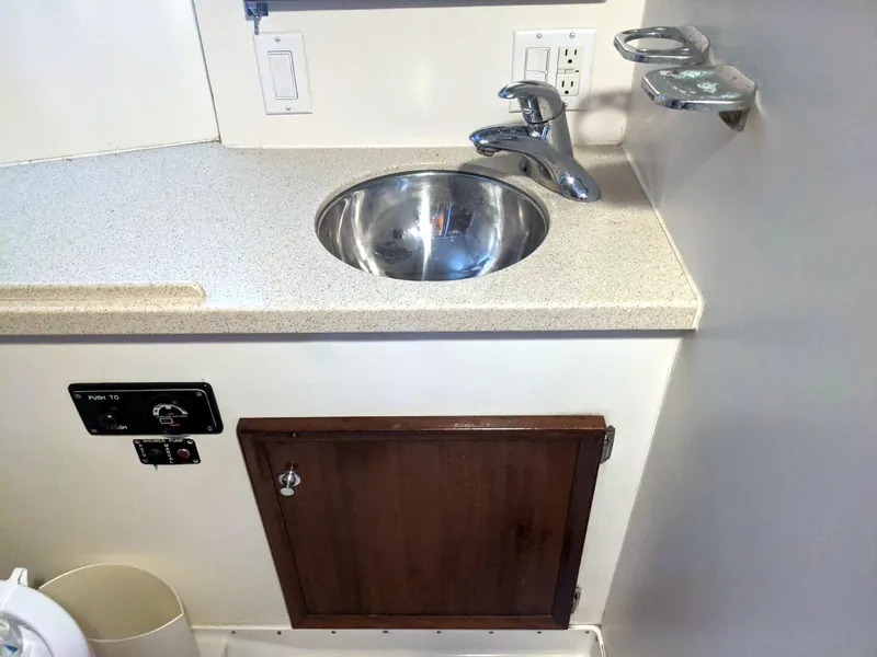 Slide: The Image of 1977 Hatteras 46 Convertible yacht bathroom sink with countertop and storage cabinet. - 28