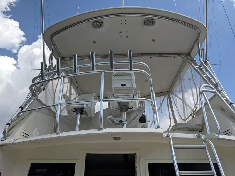 Slide: The Image of 1977 Hatteras 46 Convertible yacht with flybridge and ladder, under a clear blue sky. - 3