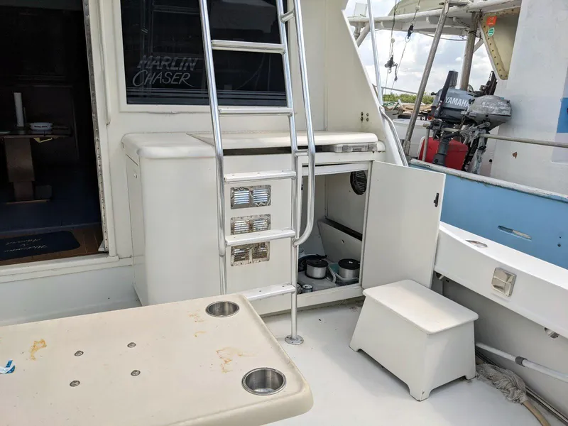 Slide: The Image of 1977 Hatteras 46 Convertible yacht deck with ladder and open storage compartment. - 30