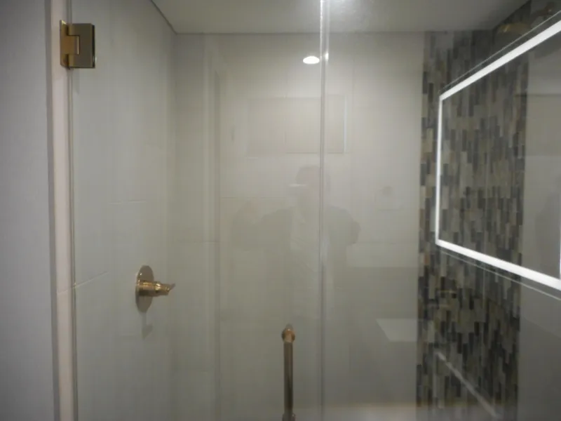 Slide: The Image of Modern bathroom with glass shower door, mosaic tile wall, and illuminated mirror. Adonia Melody Share #12, 2021. - 13