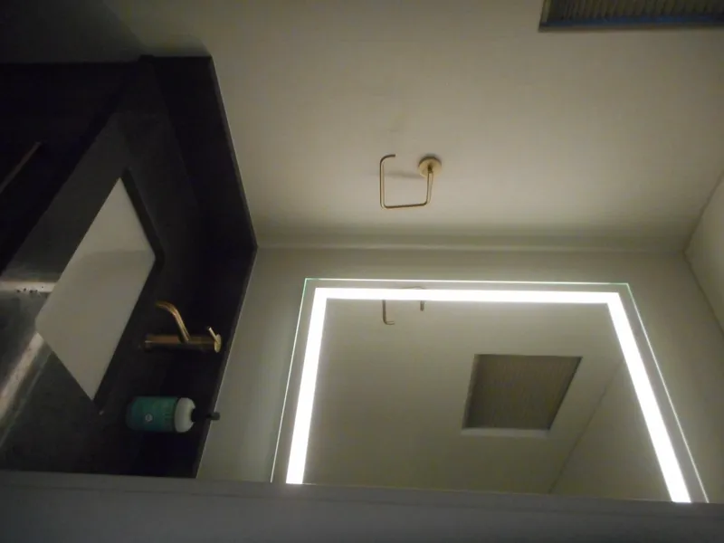 Slide: The Image of Modern bathroom with illuminated mirror, dark countertop, and gold faucet. Adonia Melody Share #12, 2021. - 19