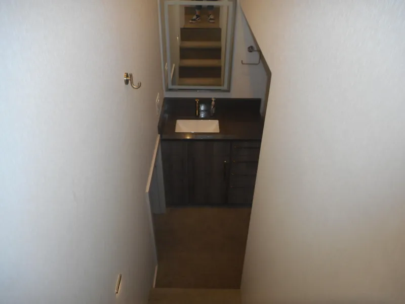 Slide: The Image of Narrow bathroom with dark vanity, mirror, and sink in Adonia Melody Share #12, 2021 model. - 32