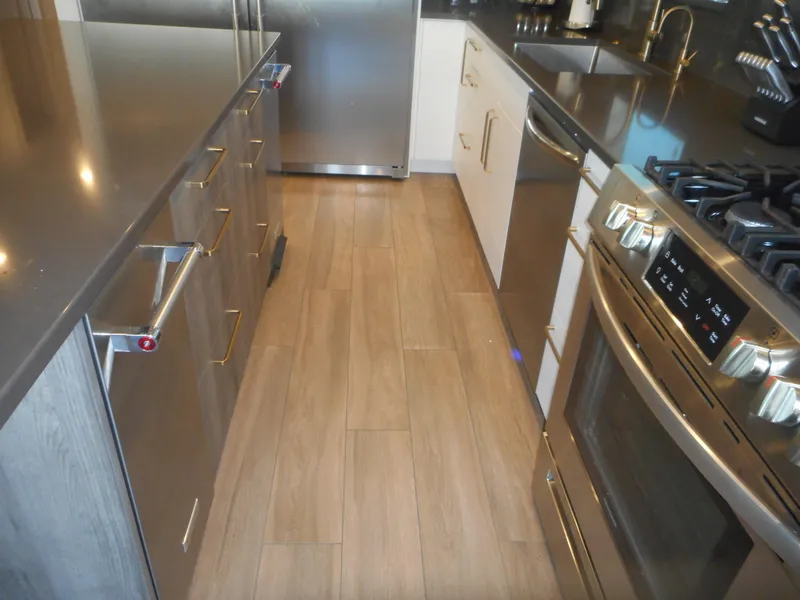 Slide: The Image of Modern kitchen with stainless steel appliances, wooden flooring, and sleek countertops. Adonia Melody Share #12, 2021. - 40