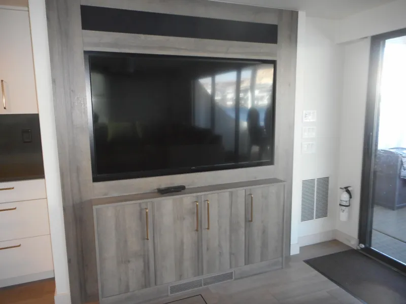 Slide: The Image of Modern entertainment center with large TV, wooden cabinet, and sleek design in a contemporary room. - 42