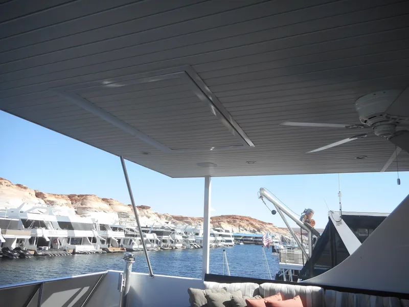 Slide: The Image of Houseboat deck view with marina, featuring Adonia Melody Share #12, 2021 model, under a clear sky. - 49