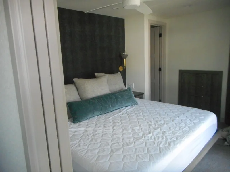 Slide: The Image of Modern bedroom with a neatly made bed, decorative pillows, and minimalist decor in Adonia Melody Share #12. - 9