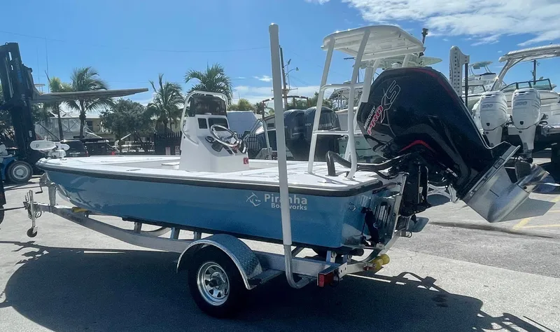 Slide: The Image of 2025 Piranha Magro P180 boat on trailer, parked outdoors under clear sky. - 2