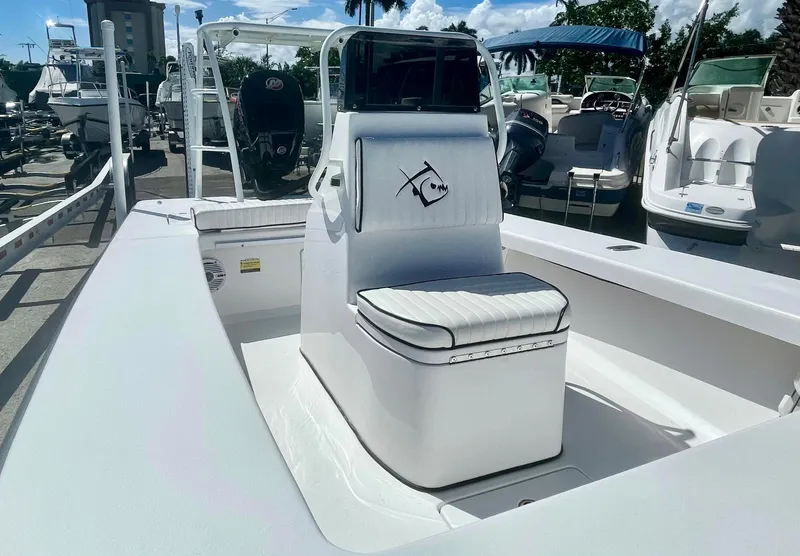 Slide: The Image of 2025 Piranha Magro P180 boat with sleek white seating and console, docked under a sunny sky. - 6