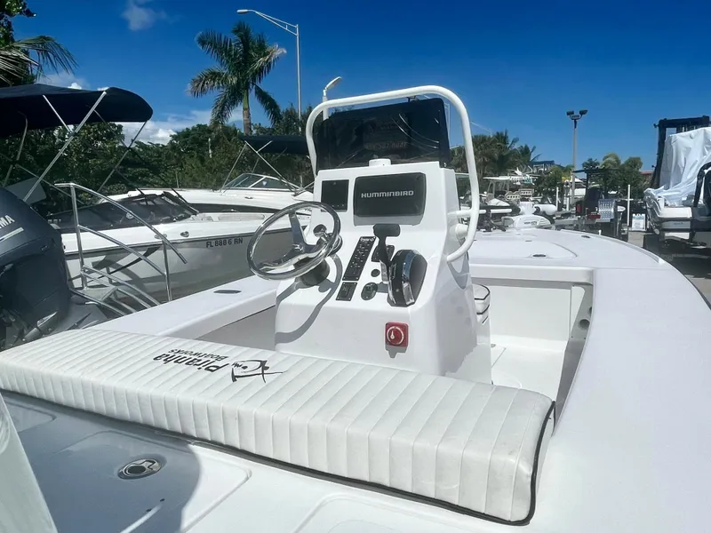 Slide: The Image of 2025 Piranha Magro P180 boat with sleek console and steering, docked under clear blue sky. - 9