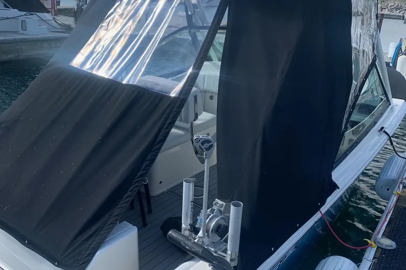 Slide: The Image of 2022 Cobia 240 DC boat with black canopy, docked at marina. - 11