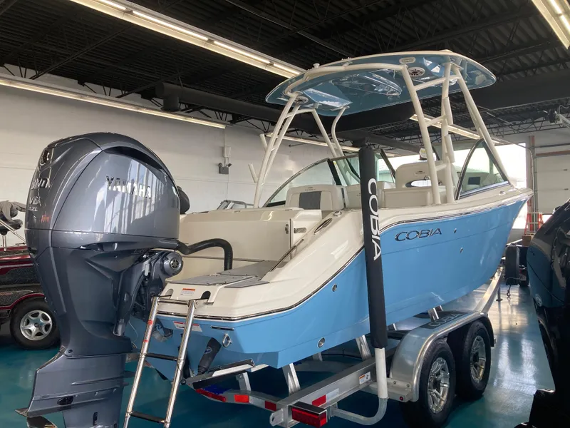 Slide: The Image of 2022 Cobia 240 DC boat on trailer with Yamaha outboard motor in showroom. - 14
