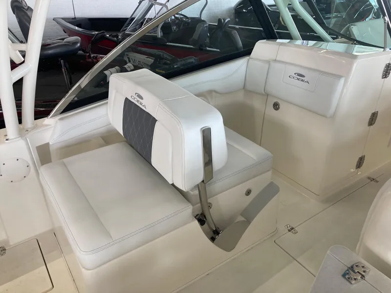Slide: The Image of 2022 Cobia 240 DC boat interior with white seating and sleek design. - 23