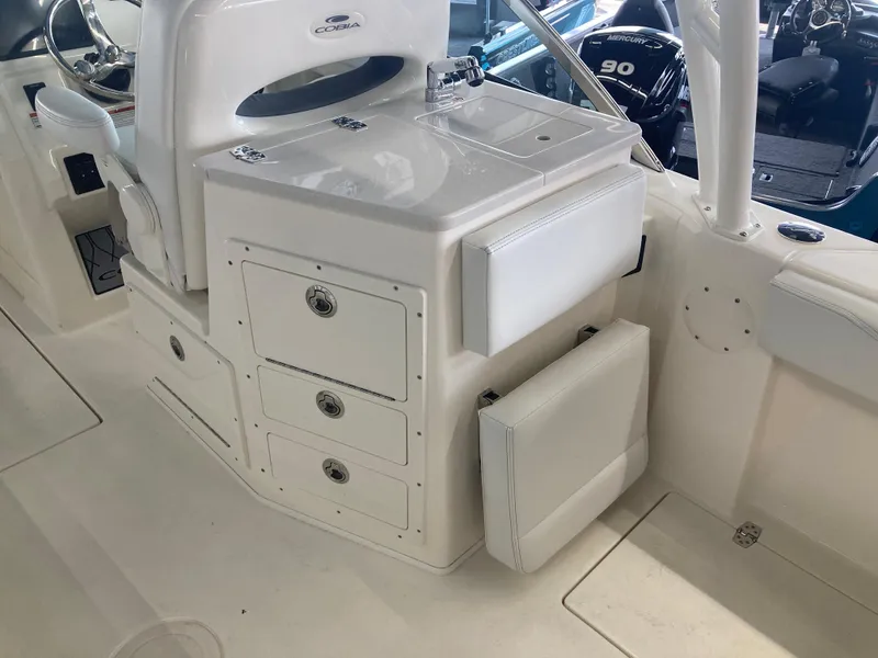 Slide: The Image of 2022 Cobia 240 DC boat interior with storage drawers and seating. - 24