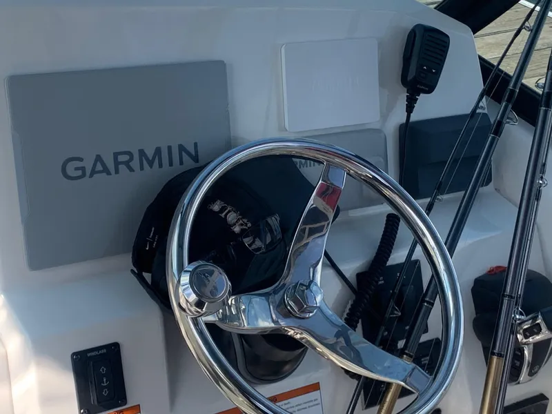 Slide: The Image of Steering wheel and Garmin system on 2022 Cobia 240 DC boat dashboard. - 29