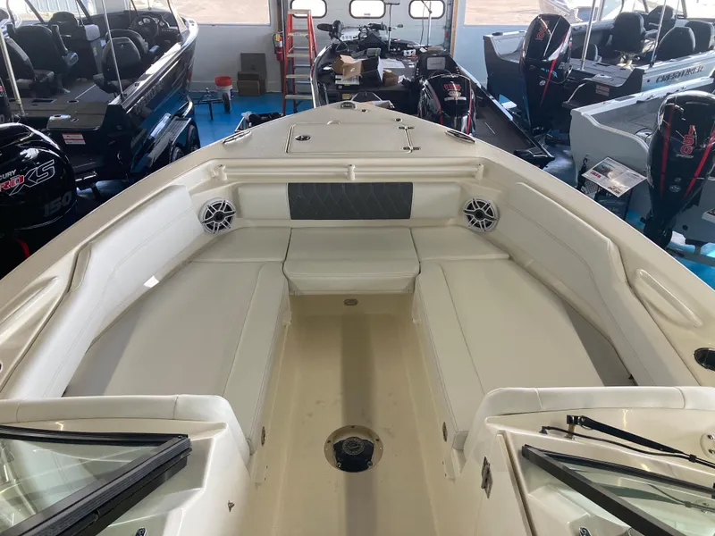Slide: The Image of 2022 Cobia 240 DC boat interior with seating and speakers in showroom. - 31