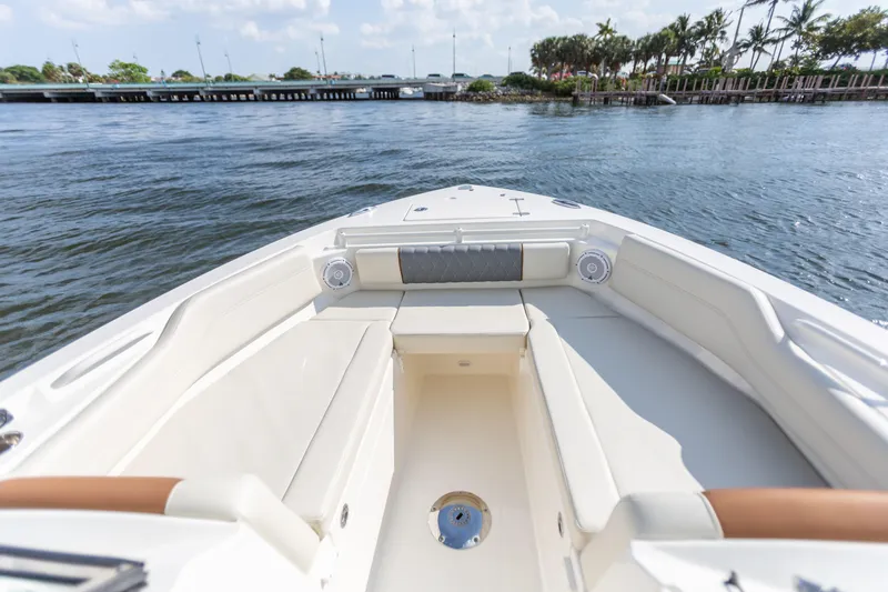 Slide: The Image of 2022 Cobia 240 DC boat interior with seating, on a sunny day by the water. - 35