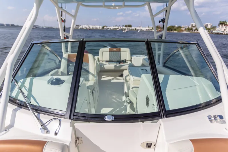 Slide: The Image of 2022 Cobia 240 DC boat interior with seating, viewed from the bow on a sunny day. - 36