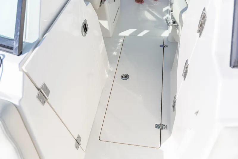 Slide: The Image of 2022 Cobia 240 DC boat interior with storage compartment and sleek white finish. - 37
