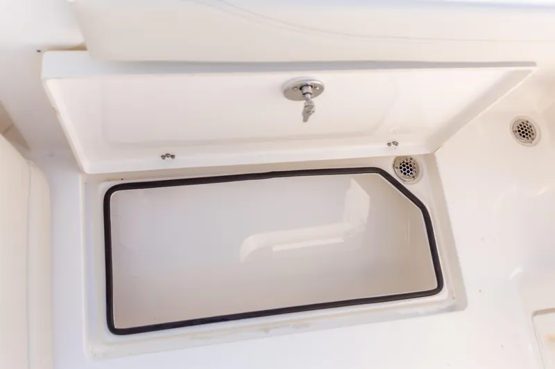 Slide: The Image of Storage compartment on a 2022 Cobia 240 DC boat, featuring a secure latch. - 45