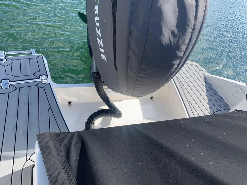 Slide: The Image of 2022 Cobia 240 DC boat with covered engine, docked on water. - 7