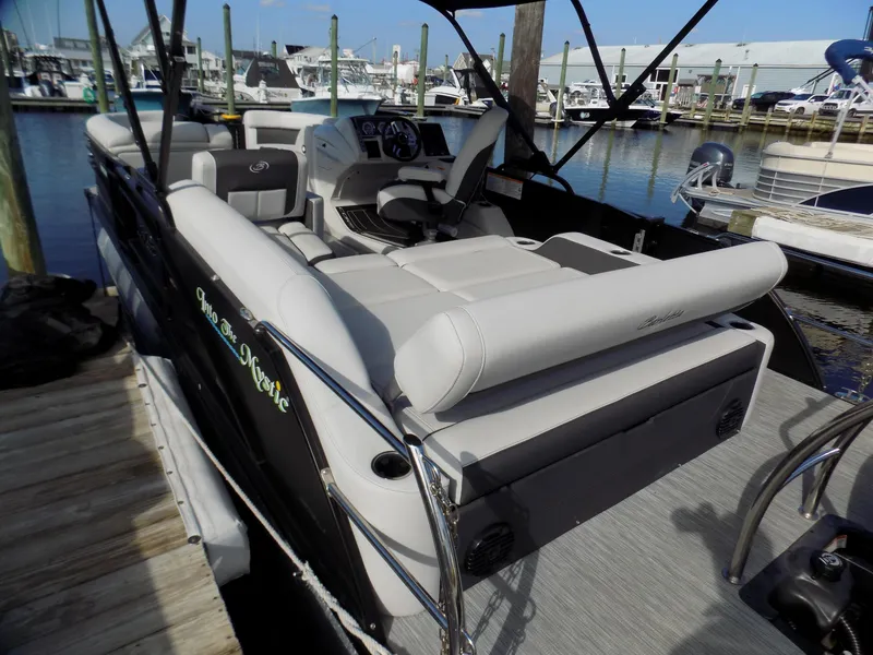 Slide: The Image of 2021 Barletta Corsa 23U pontoon boat docked, featuring spacious seating and modern controls. - 4