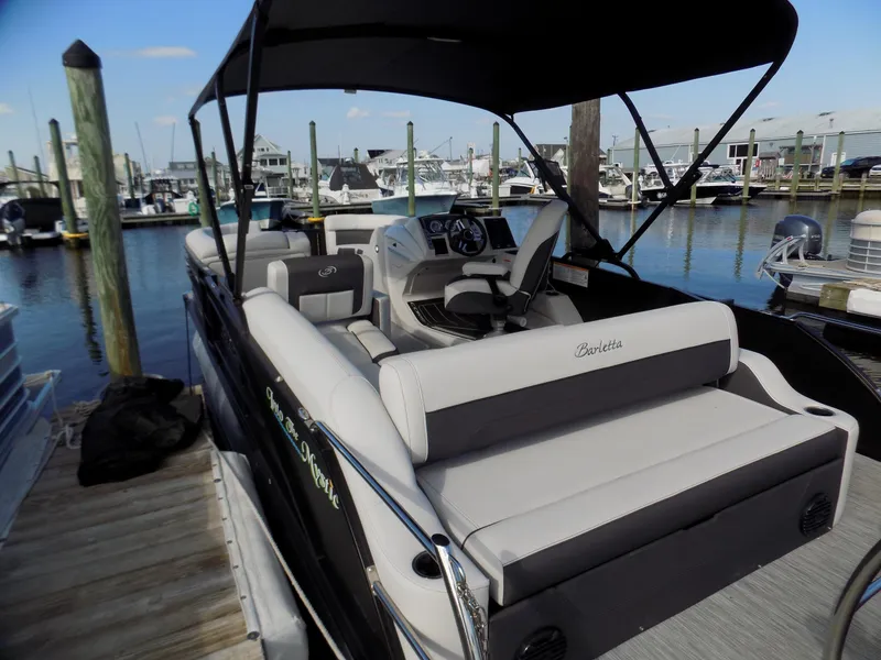 Slide: The Image of 2021 Barletta Corsa 23U pontoon boat docked at marina, featuring spacious seating and canopy. - 5