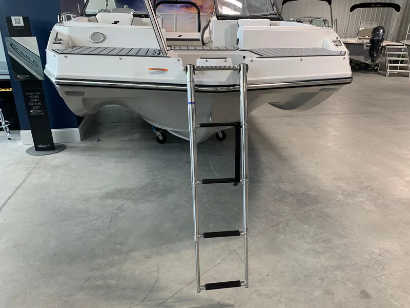 Slide: The Image of 2024 Starcraft SVX 210 boat with a boarding ladder in a showroom. - 15