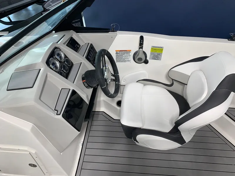 Slide: The Image of 2024 Starcraft SVX 210 boat cockpit with steering wheel and captain's chair. - 5