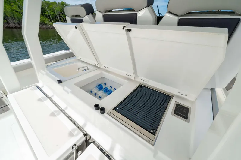 Slide: The Image of 2025 Pursuit S 358 boat with open storage compartments and cooler. - 17