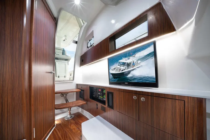 Slide: The Image of Interior of 2025 Pursuit S 358 boat with wooden cabinetry and mounted TV. - 25