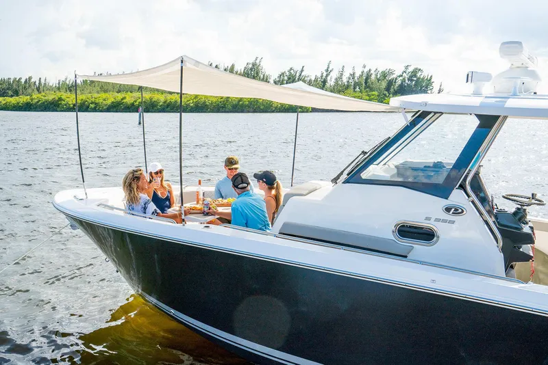 Slide: The Image of 2025 Pursuit S 358 boat with people enjoying a sunny day on the water. - 4