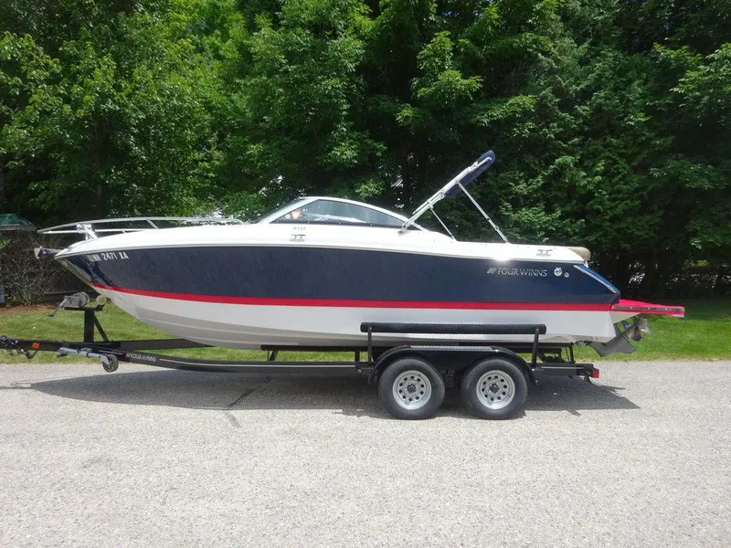 Slide: The Image of 2015 Four Winns Sundowner 235 boat on trailer, side view, parked outdoors. - 0