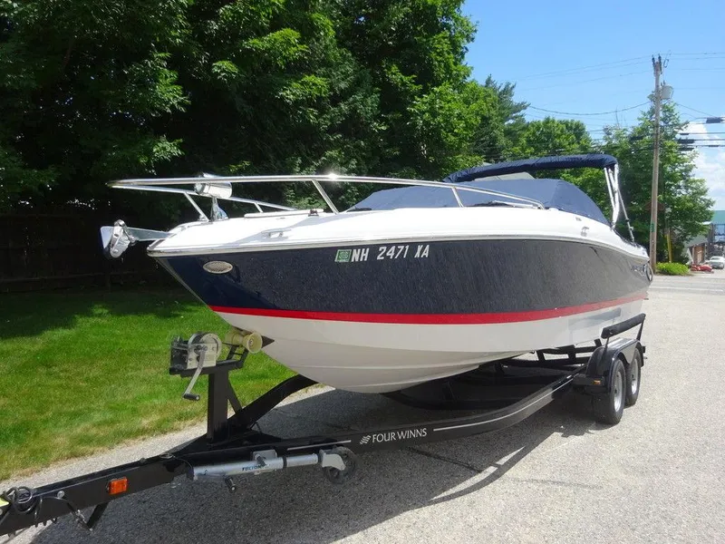Slide: The Image of 2015 Four Winns Sundowner 235 boat on trailer, parked outdoors. - 1