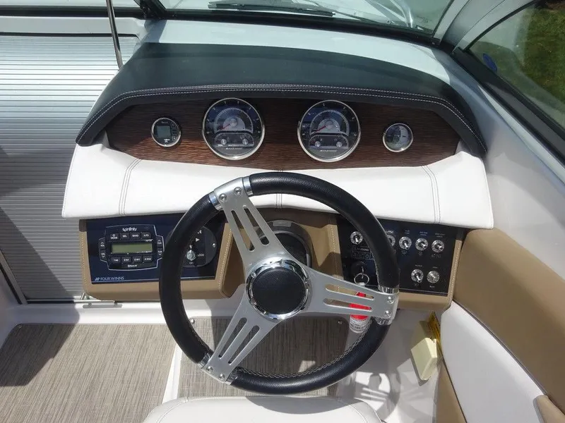 Slide: The Image of 2015 Four Winns Sundowner 235 boat dashboard with steering wheel and instrument panel. - 12