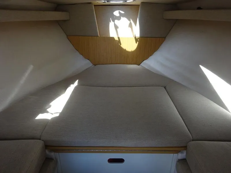 Slide: The Image of 2015 Four Winns Sundowner 235 cabin interior with cushioned sleeping area. - 16