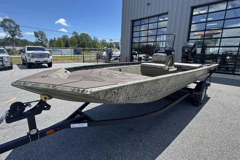The Image of 2024 Tracker GRIZZLY® 1860 CC boat on trailer, parked outside dealership. - 2