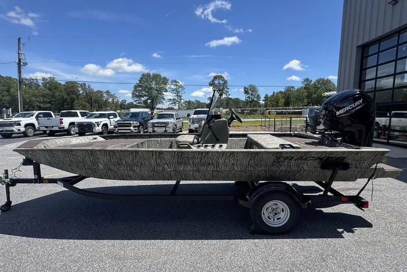 Slide: The Image of 2024 Tracker GRIZZLY® 1860 CC boat on trailer, parked outdoors under clear sky. - 5