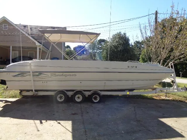 Slide: The Image of 1998 Bayliner 2659 Rendezvous boat on a trailer in a driveway. - 2