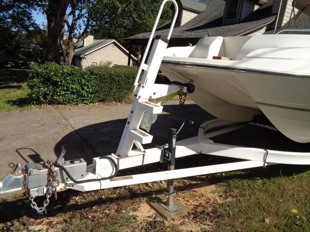 Slide: The Image of 1998 Bayliner 2659 Rendezvous boat on a trailer in a residential driveway. - 4