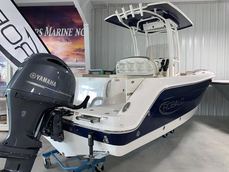 Slide: The Image of 2024 Robalo R222 Explorer boat with Yamaha outboard motor in showroom. - 1