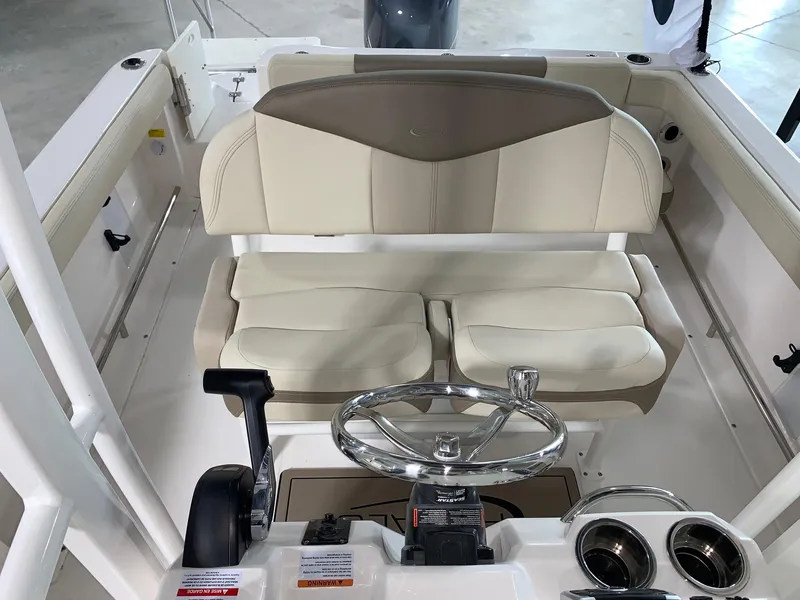 Slide: The Image of 2024 Robalo R222 Explorer boat interior with steering wheel and cushioned seating. - 10