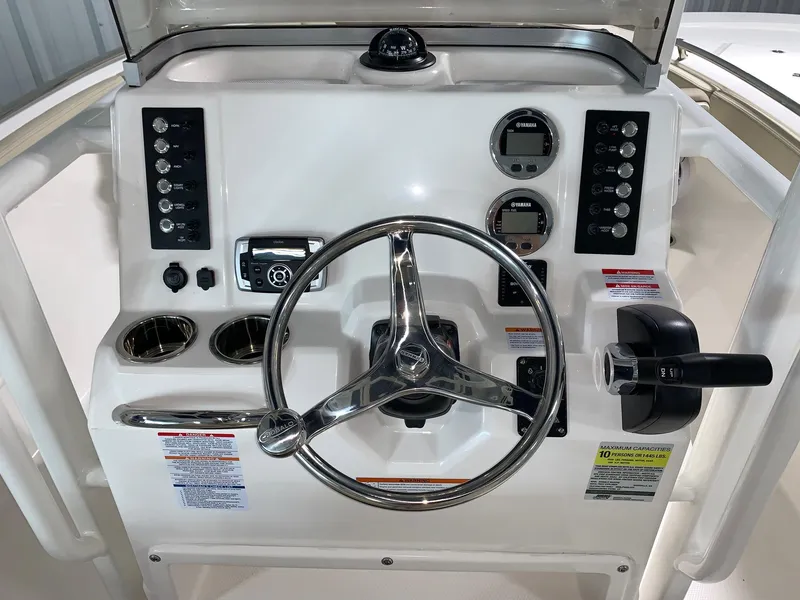 Slide: The Image of 2024 Robalo R222 Explorer boat dashboard with steering wheel and control panel. - 6