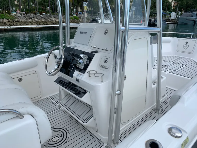 Slide: The Image of 2006 Century 2600CC boat interior with steering wheel and control panel, docked by water. - 13