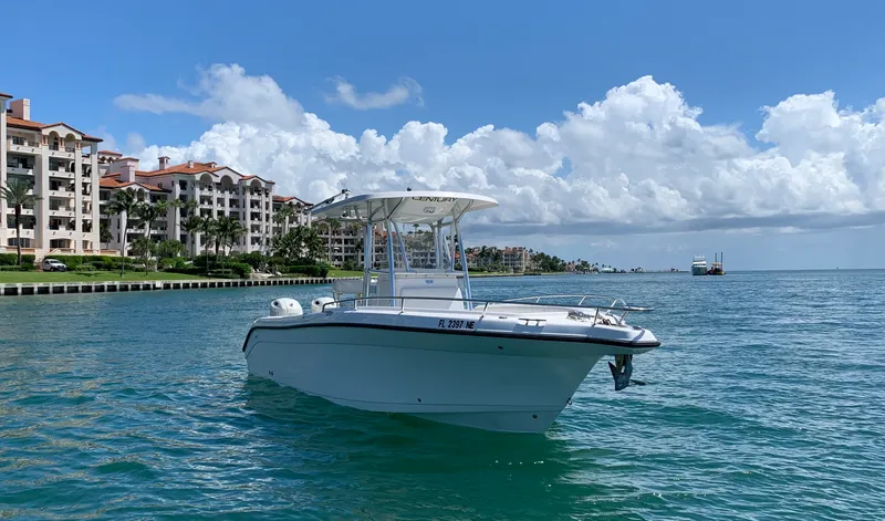 Slide: The Image of Century 2600CC boat on water near coastal buildings, clear sky, 2006 model. - 2