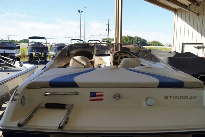 Slide: The Image of 2002 Stingray 180LX boat with American flag, docked in a covered marina. - 4